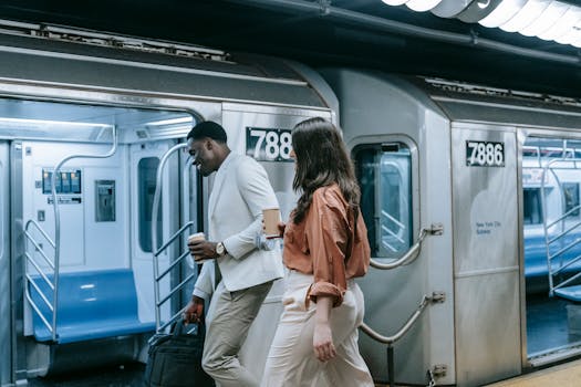 Two colleagues walking on the New York subway platform, engaging in casual conversation.
